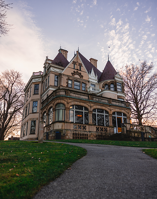 exterior view of a gilded age mansion at sunset