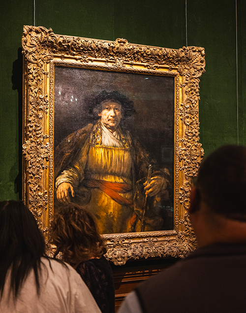 a group of people standing in front of rembrandt's self-portrait