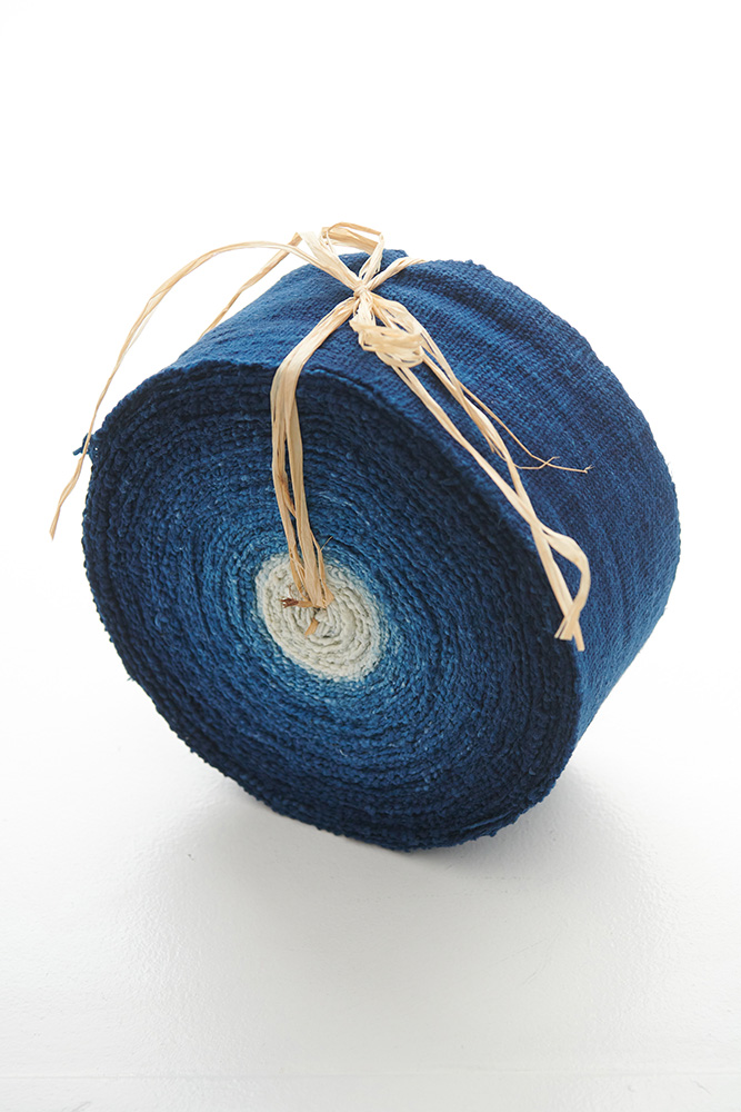 a blue strip of fabric rolled up and tied with twine