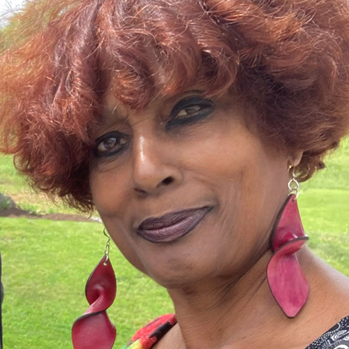 a black woman with curly hair and large pink earrings