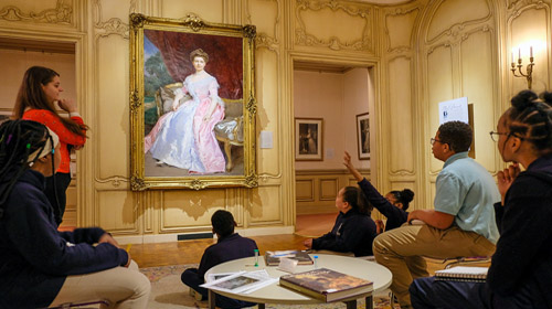 a group of school children explore an art museum with an educator