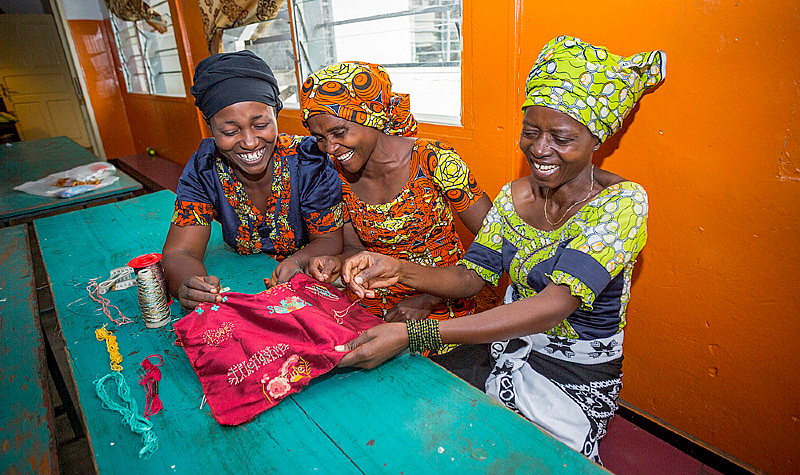 Artisans Gisele, Esther, and Esperance work on The Red Dress. Photo by Nicole Esselen.