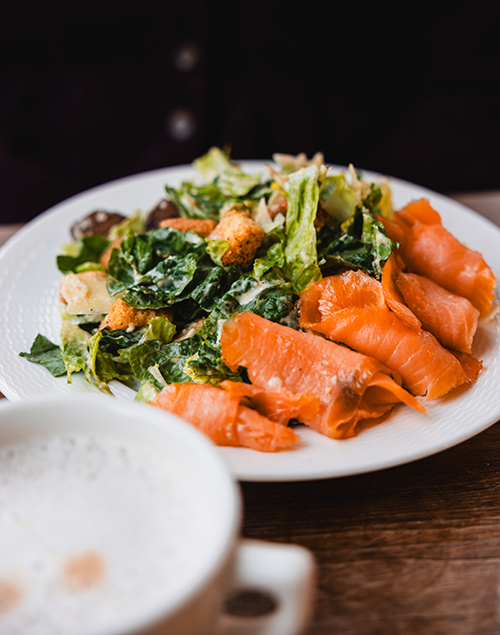 a plate of salad topped with smoked salmon