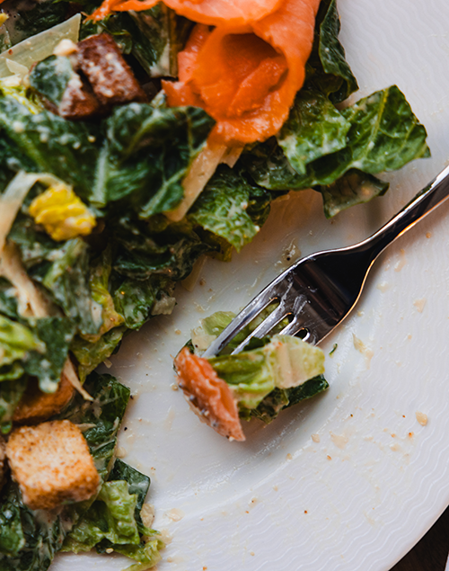 a plate of salad topped with smoked salmon