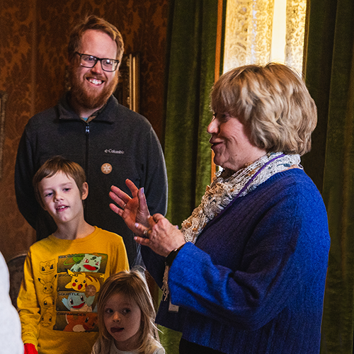 two kids and their dad listen to a tour guide