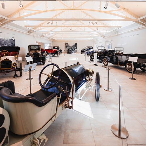 a bright museum space filled with vintage cars