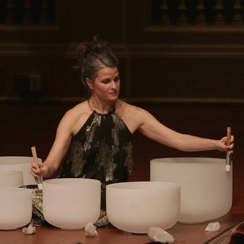 A woman on a stage playing a set of bowls